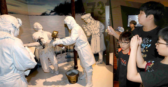 「日本第７３１部隊の細菌戦」特別展示会で観覧客が生きている人を冷凍させる場面を演出した展示物を見ていた。