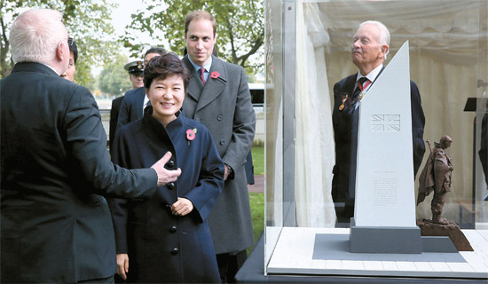 朴槿恵（パク・クネ） 大統領が５日午後（英国時間）、ロンドン国防部近郊のエンバークメントガーデンで開かれた「韓国戦争参戦記念碑起工式」に参加して、記念碑模型を見ながら設計者のトニー・ダイソン氏から説明を聞いた。朴大統領の右側にいるのはウィリアム王子。