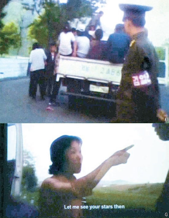 無許可バス取り締まりに抗議する女性…北朝鮮の住民たちが無許可バス営業をするトラックに乗る場面を検閲官が見守っている（上）。無許可バス営業を制止された女性が、関係を連れてこいと言って検閲官を指差している（下）。英国公営放送チャネル４の画面をＪＴＢＣが撮影後キャプチャーした。