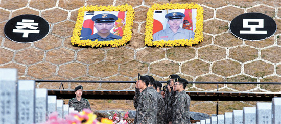 延坪島挑発３周忌となる２３日を控え当時北朝鮮の砲撃で戦死したソ・ジョンウ下士とムン・グァンウク一等兵の墓地がある大田顕忠院に参拝客が続いている。彼らの墓地のそばに２人の戦死者の大型写真が掲げられた「追慕の丘」が作られた。２０日午後、軍将兵が墓地の前で挙手敬礼している。