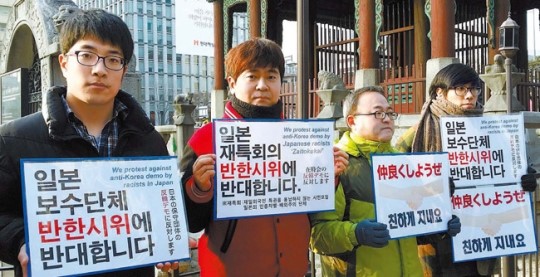 桜井信栄教授（左から２人目）が主軸になった「反韓デモに反対するデモ」が開かれた。デモ隊は「日本の右翼の人種差別に強く反対する」というメモをミカンとともに市民に配った。