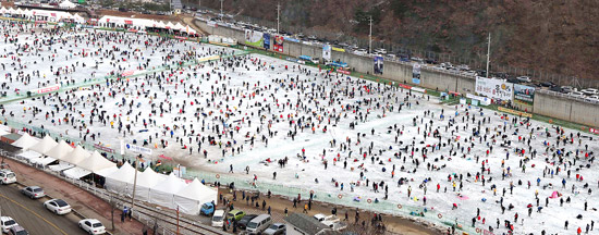 ５日、華川の氷上野外釣り場で、観光客が約１万２０００か所の丸い穴の中に釣り竿を垂らしている。