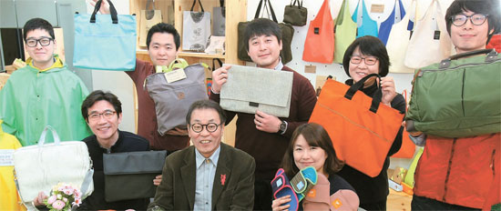 「ザ・ナヌギ」は捨てられる布切れなどでデザイン製品を作る会社。チョン・ヨンビン代表（前列の真ん中）が職員と写真撮影している。