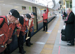 新幹線の掃除前に乗客にあいさつするテッセイの職員。