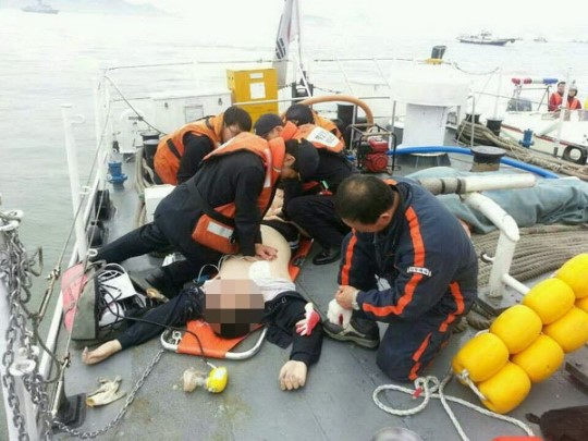 １６日、珍島旅客船沈没事故の救助作業に駆けつけた海洋警察職員が、乗客に応急心肺蘇生術を施している。（写真＝韓国海洋警察）