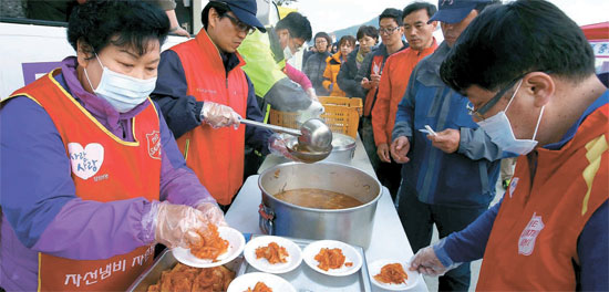 救世軍慈善鍋本部のボランティアメンバーが１９日、珍島の彭木（ペンモク）港で炊き出しをしている。