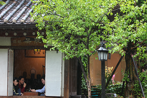 新緑に囲まれた伝統茶店では、雨宿りを兼ねてお茶とお菓子で休憩する人々も。雨音をききながら、温かい伝統茶を味わうのも雨の日ならではの楽しみ方ですね。