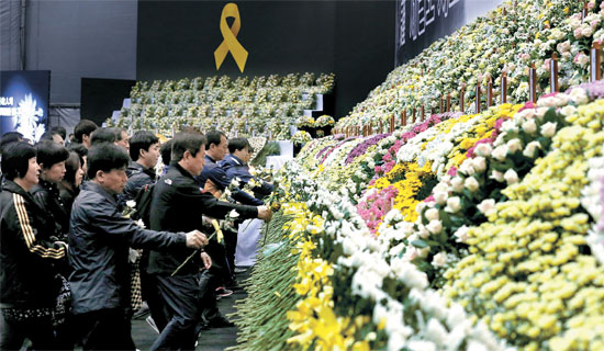 ２９日、京畿道安山花郎遊園地に設置された「セウォル号」犠牲者のための政府合同献花台で、弔問客が犠牲者を追悼している。安山献花台は犠牲者の合同告別式まで２４時間運営される。午前９時から午後１１時まで４号線の古桟駅からシャトルバスが１０－１５分間隔で出ている。