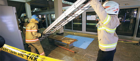 １９日午後６時５０分ごろ、京畿道軍浦市の地下鉄４号線衿井駅で電車上部に取り付けられていた電気絶縁装置が爆発して乗客１１名が負傷する事故が発生した。消防隊員が事故現場を収拾している。