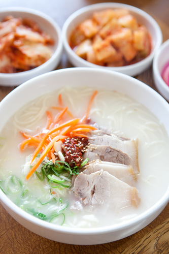 珍しい豚肉入り麺（コギクッス）は、豚肉独特の臭みを取り除きあっさりと食べやすい味付け。１日以上煮込んだ豚骨スープと素麺の相性も抜群で、釜山（プサン）名物の豚肉スープご飯（テジクッパ）とも似ています。