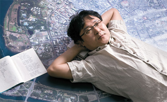北朝鮮専門インターネット新聞「ニューフォーカス」のソウル論硯洞（ノンヒョンドン）のオフィスに広げられた平壌（ピョンヤン）衛星写真の上に横になった張真晟詩人。ノートは彼が脱北する時に持ってきた詩作ノート。