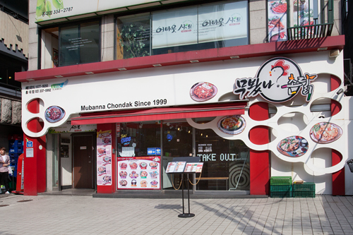 スパイシーなコチュジャンチキンで知られる「ムバンナ チョンタッ」も釜山出身のチキン専門店。店名は「食べてみたか？田舎の鶏」という意味の方言です。好みの辛さに調節できるカスタマイズ感と、チキンの風味が残るタレにご飯を混ぜる独特の食べ方で人気を呼び、弘大、新村（シンチョン）、江南（カンナム）駅など若者の街を中心に全国に約４０店展開中。