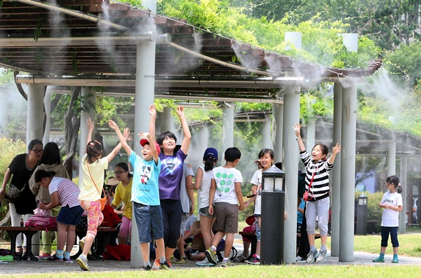 １９日、大邱中区の国債補償運動記念公園にクーリングフォグシステムが設置された。子どもたちがベンチのそばで涼んでいる。
