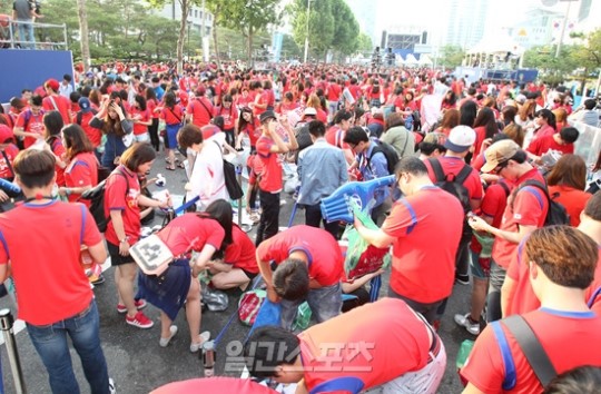 ブラジルワールドカップ（Ｗ杯）Ｈ組の韓国－ベルギー戦が行われた２７日、ソウル永東大路で街頭応援をしたサッカーファンが、競技が終わった後にゴミを片付けている。