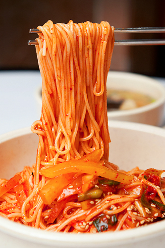 そうめんにピリッと唐辛子のきいたコチュジャンのタレを絡めて食べるビビングッス。白い麺にかかった真っ赤なタレが食欲をそそります。