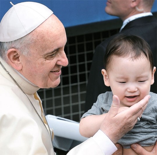 子どもの顔をなでるローマ法王