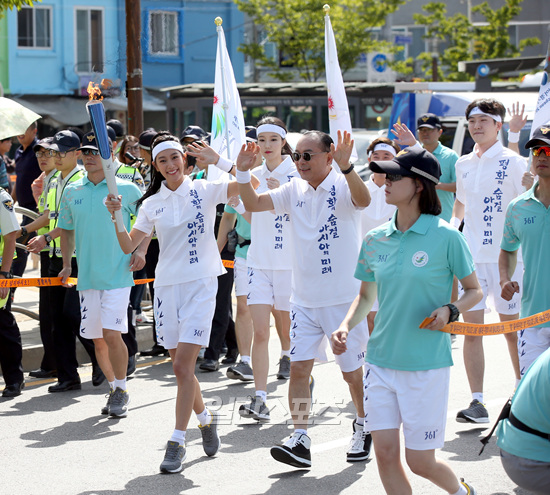 １８日午後、仁川東区の聖火リレーランナーとして歌手で父親のイ・スンギュさん（右）と共に登場した女優のクララ。