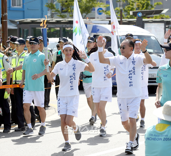 １８日午後、仁川東区の聖火リレーランナーとして歌手で父親のイ・スンギュさん（右）と共に登場した女優のクララ。