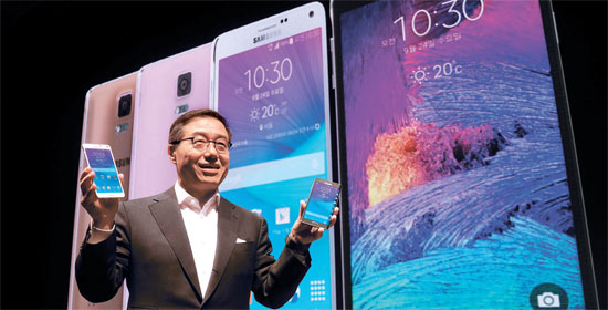 サムスン電子のイ・ドンジュ無線事業部戦略マーケティング室長（社長）が２４日、「ギャラクシーノート４ワールドツアー２０１４」でギャラクシーノート４（左）とギャラクシーノートエッジを紹介している。（写真＝サムスン電子）