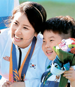 仁川アジア競技大会射撃女子ダブルトラップ個人戦で金メダルを獲得したキム・ミジンが息子と一緒に記念撮影をしている。（写真＝共同取材団）