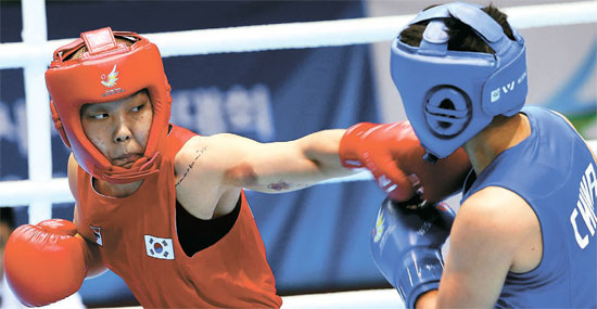 パク・ジンア（２５、保寧市庁、左）が１日、仁川アジア競技大会女子ボクシング６０キロ級の決勝戦で、尹軍花（中国）を攻撃している。