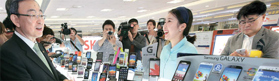 端末器流通法施行初日の１日、崔成俊（チェ・ソンジュン）放送通信委員長（左）がソウル・竜山にある携帯電話ショップを訪れた。崔委員長は「思ったより支援金が低かったが時間が過ぎれば引き上げられるだろう」と話した。