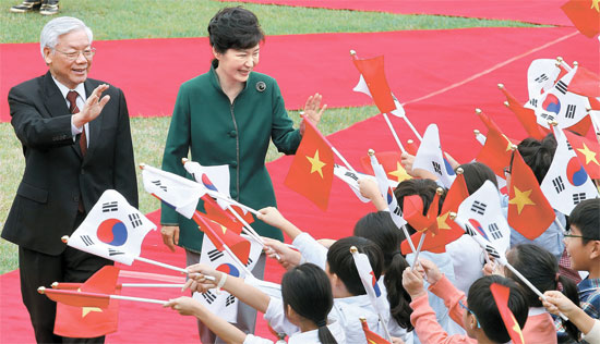 朴槿恵（パク・クネ）大統領が韓国を公式訪問したベトナムのグエン・フー・チョン共産党書記長と共に２日午前、青瓦台（チョンワデ、大統領府）で開かれた公式歓迎式に参加して子供の歓迎団に手を振っている。両首脳はこの日、単独および拡大首脳会談を相次いで開いて韓半島（朝鮮半島）非核化などを含めた共同声明を採択した。チョン書記長はベトナム権力序列１位だ