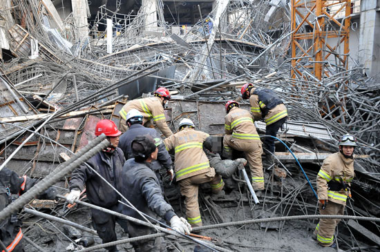 １１日午後、天井崩壊事故が発生したソウル舎堂総合体育館新築工事現場で下敷きになった作業員を救助するために消防員が構造物を移動させている。（写真＝銅雀消防署）