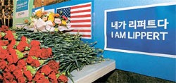 在韓米国大使館の前に６日、リッパート大使の快癒を祈願する花束が置かれている。後ろに「私はリッパート」という文字が見える。