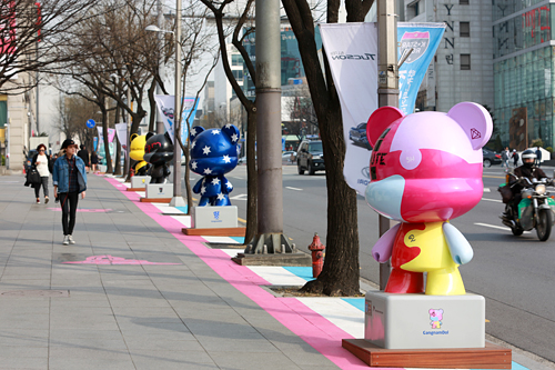 江南＋アイドル＋人形（Ｄｏｌｌ）を組み合わせた「江南ドル」と名付けられたオブジェは道路沿いに１１体展示中。クマをモチーフにしており、東方神起、２ＰＭ，ＣＮＢＬＵＥなどのロゴやイメージカラーがデザインされています。