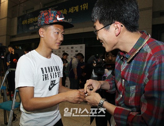 １５日午後、仁川（インチョン）空港を通じて入国したＦＣバルセロナの有望選手、李承佑が空港入国ゲートでファンにサインをしている。