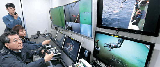 韓国海洋科学技術院の研究員、ペク・セフンさん、キム・バンヒョンさん、キム・ウンソさん（後方から）が１８日、巨済島の南海研究所で深海用の遠隔無人操縦潜水艇（ＲＯＶ）「ヘミレ」を操縦し、性能テストをしている。