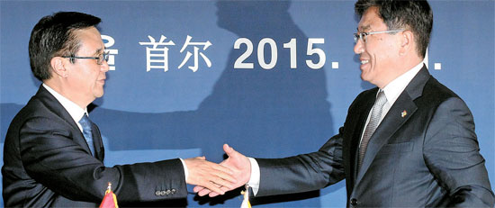 尹相直（ユン・サンジク）産業通商資源部長官（右）と高虎城中国商務相が１日、ソウルグランドハイアットホテルで韓中自由貿易協定書に署名した後、握手している。