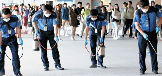 ３日午後、仁川国際空港の防疫要員が入国ゲート全体に殺菌消毒剤を散布している。