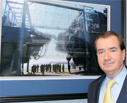 執務室の壁にかかった韓国哨戒艦「天安」の残骸写真の前に立つエド・ロイス米下院外交委員長。