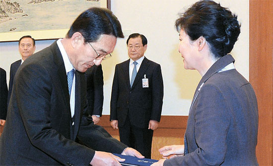 朴槿恵（パク・クネ）大統領が１３日午前、青瓦台（チョンワデ、大統領府）首席秘書官会議に先立ち玄伎煥（ヒョン・ギファン）新任政務首席に任命状を手渡している。朴大統領は「国家の発展と国民の大統合を実現するために赦免を実施する必要がある」として関連首席に範囲と対象を検討するよう指示した。（写真＝青瓦台写真記者団）