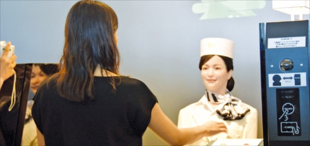 長崎の「変なホテル」でロボット職員（写真右）がチェックインサービスを行っている。