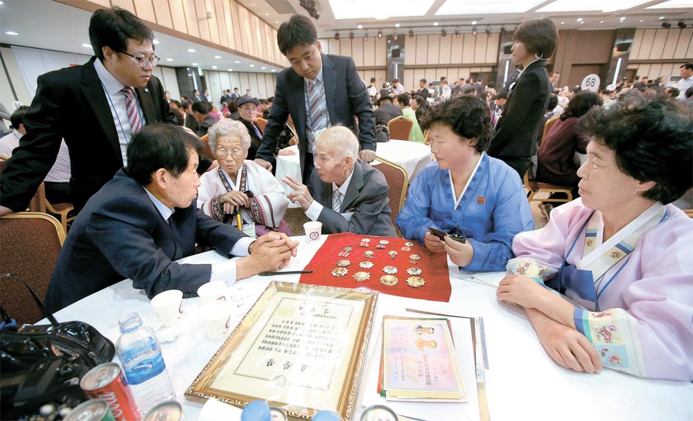 南側と北側の離散家族５３０人が２０日午後、北朝鮮の金剛山離散家族面会所で再会した。南側のイ・オクヨンさん（８８、座っている人の左から２人目）が北側から来た夫のチェ・フンシクさん（８８、左から３人目）と６５年ぶりに会い、話をしている。左側は息子のヒヤンさん（６５）。（金剛山＝写真共同取材団）