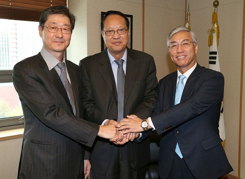 張宝文副委員長（真ん中）が同行した邱国洪駐韓中国大使（右）、宋弼鎬（ソン・ピルホ）中央日報副会長と手を握って協力を誓っている。