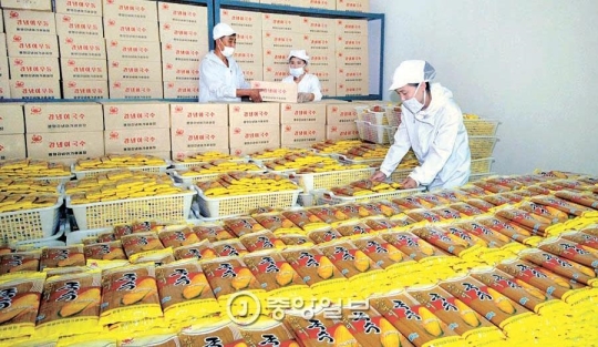 平壌トウモロコシ加工工場で生産した麺を整理する職員。北朝鮮の新興富裕層「トンジュ（金主）」は市場の価格動向を把握し、商品供給量を調節してお金を稼いでいる。（写真＝中央フォト）