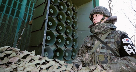 中部前線の兵士が放送のために拡声器偽装幕を取り除いている。（写真＝共同取材団）