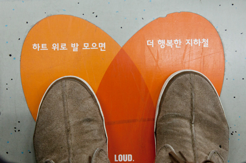 韓国語でプロジェクト名が書かれており、ハートの中に足を置けば自然とマナー良く座ることができます。