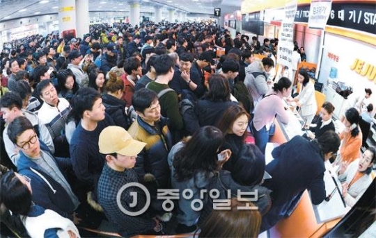 大雪で全面統制された済州（チェジュ）空港の航空機運航が２５日午後に再開された。済州を離れようとする乗客が集まり、航空会社の発券窓口が混雑している。