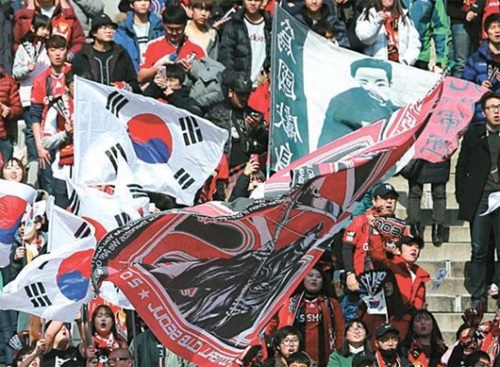 太極旗と安重根（アン・ジュングン）義士が描かれた旗を振るＦＣソウルの応援団。（写真＝韓国プロサッカー連盟）