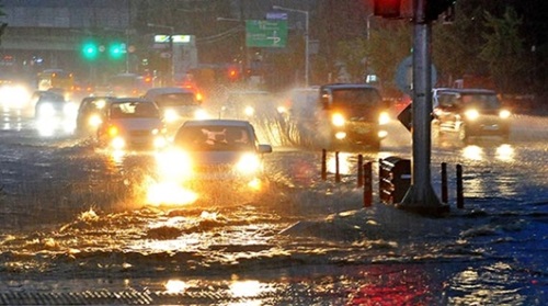 中部地方を襲った豪雨で４日夕方、大田市西区関雎洞（テジョンシ・ソグ・クヮンジョドン）西一（ソイル）高校前の西大田（ソデジョン）ＩＣ付近道路が冠水した。自動車がしぶきを上げながら走行している。
