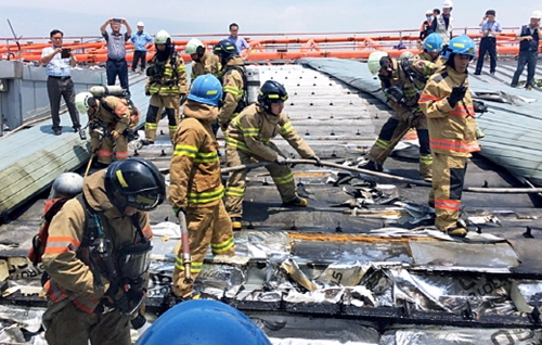 消防隊員が今月１１日、韓国の金浦空港国内線ターミナル３階屋上遮光幕で発生した火災の残火処理を行っている。（写真提供＝江西消防署）