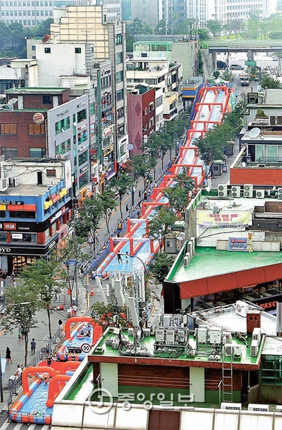 １３日から、ソウル西大門区延世路で「新村ウォータースライド２０１６」開かれ、市民が「週末歩行者天国」に設置された１２０メートルの大型ウォータースライドで水遊びを楽しんでいる。