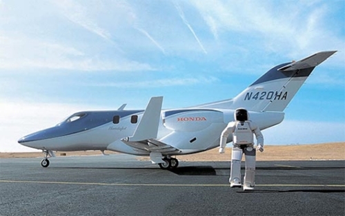 ホンダ革新の現住所を見せるジェット機「ホンダジェット」の前を同社が作ったロボット「アシモ」が歩いている。（写真＝各社）