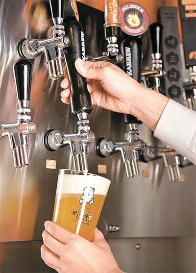 韓国製クラフトビール専門店も増えている。写真は白熊マッコリ＆醸造場でビールを注ぐ姿。