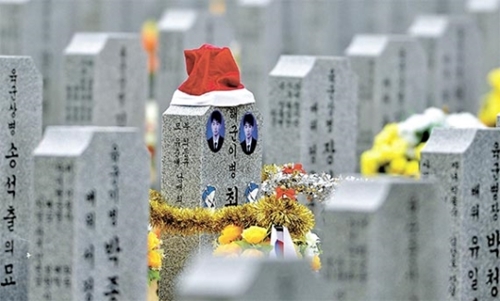 １５日、国立大田顕忠院将士兵第１墓地の故チェ・ギュヒ海軍二等兵の墓碑に鮮やかな赤色のサンタ帽が被せられている。